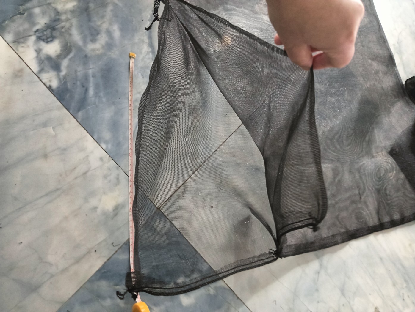 Close-up of a black breathable mesh date palm protection bag showing the Velcro closure and stitched edges