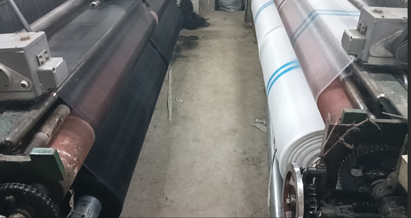 Black agricultural mesh fabric running on a production line for fruit protection bag materials