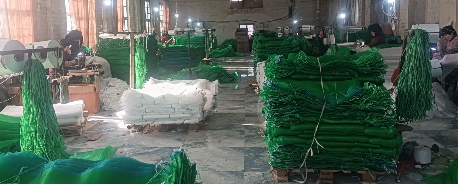 Luxin Net workshop producing green agricultural mesh netting for date palm and fruit protection bags